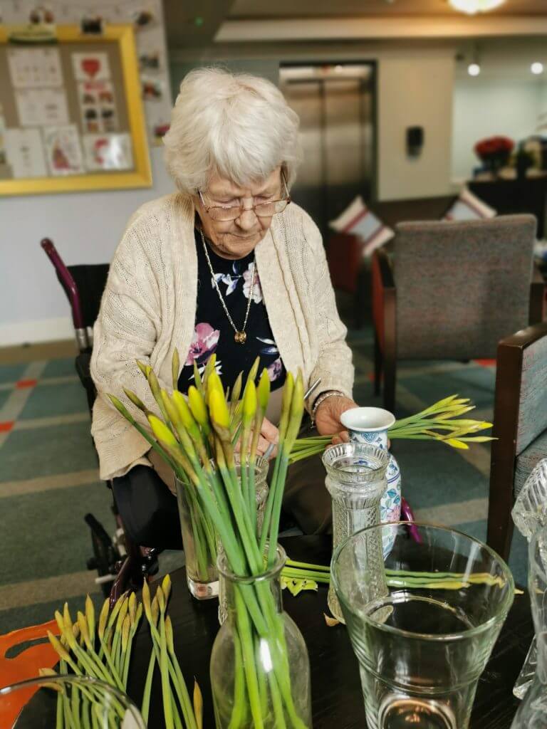 Cedar View Resident arranging daffodils